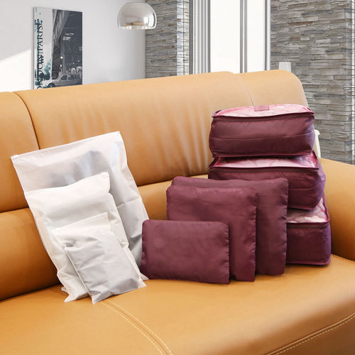 burgundy packing cubes and pouches with three frosted storage bags, nine pieces on a sofa