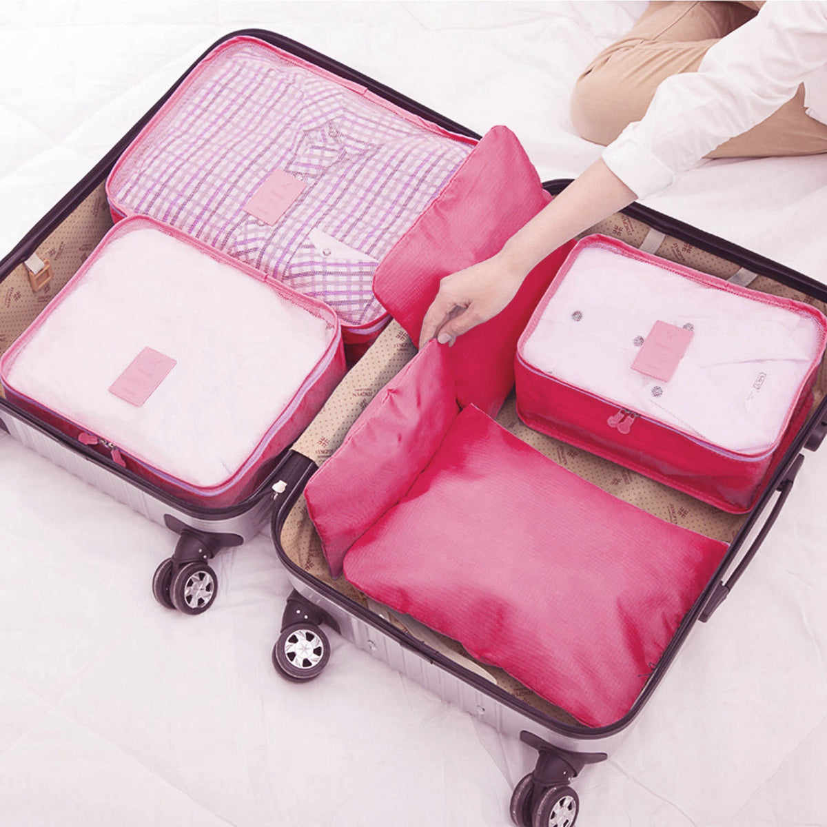 hot pink packing cubes inside a carry-on suitcase, lid open