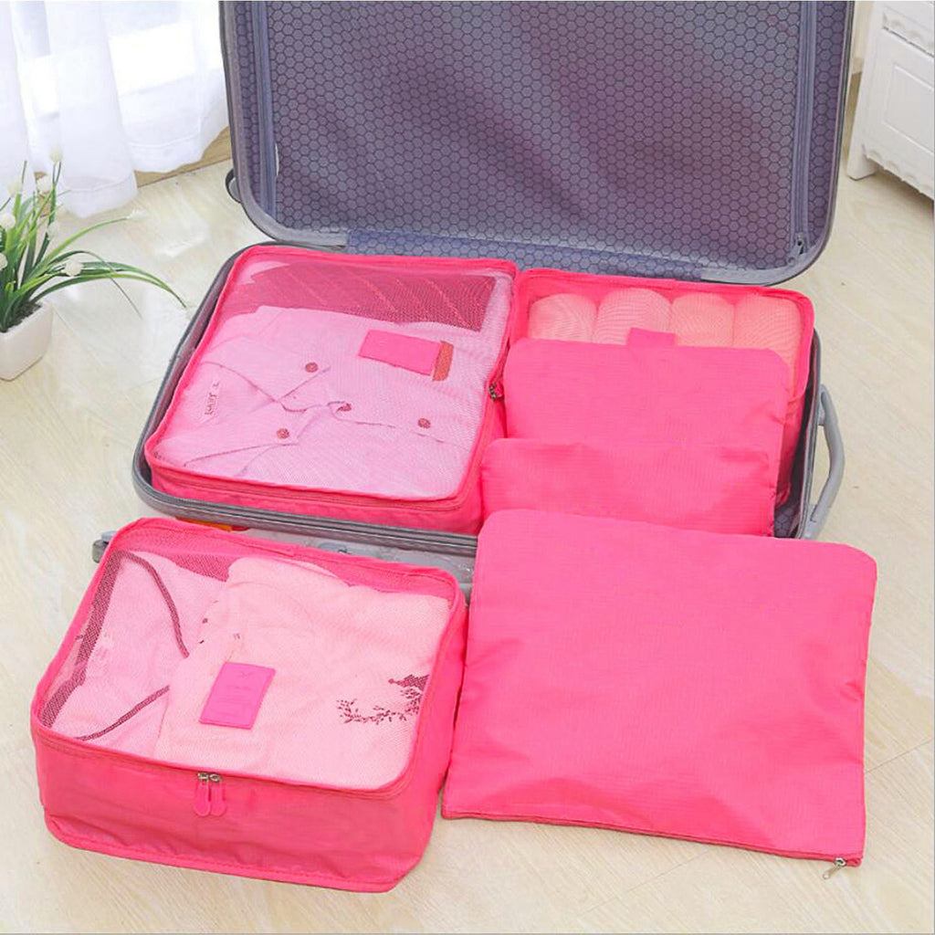 hot pink packing cubes filling one half of an open suitcase