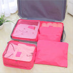 hot pink packing cubes filling one half of an open suitcase
