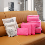 hot pink packing cubes and pouches with the three frosted storage bags on a sofa